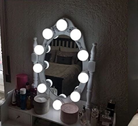 Oświetlone owalne lustro z lampkami LED na toaletce.